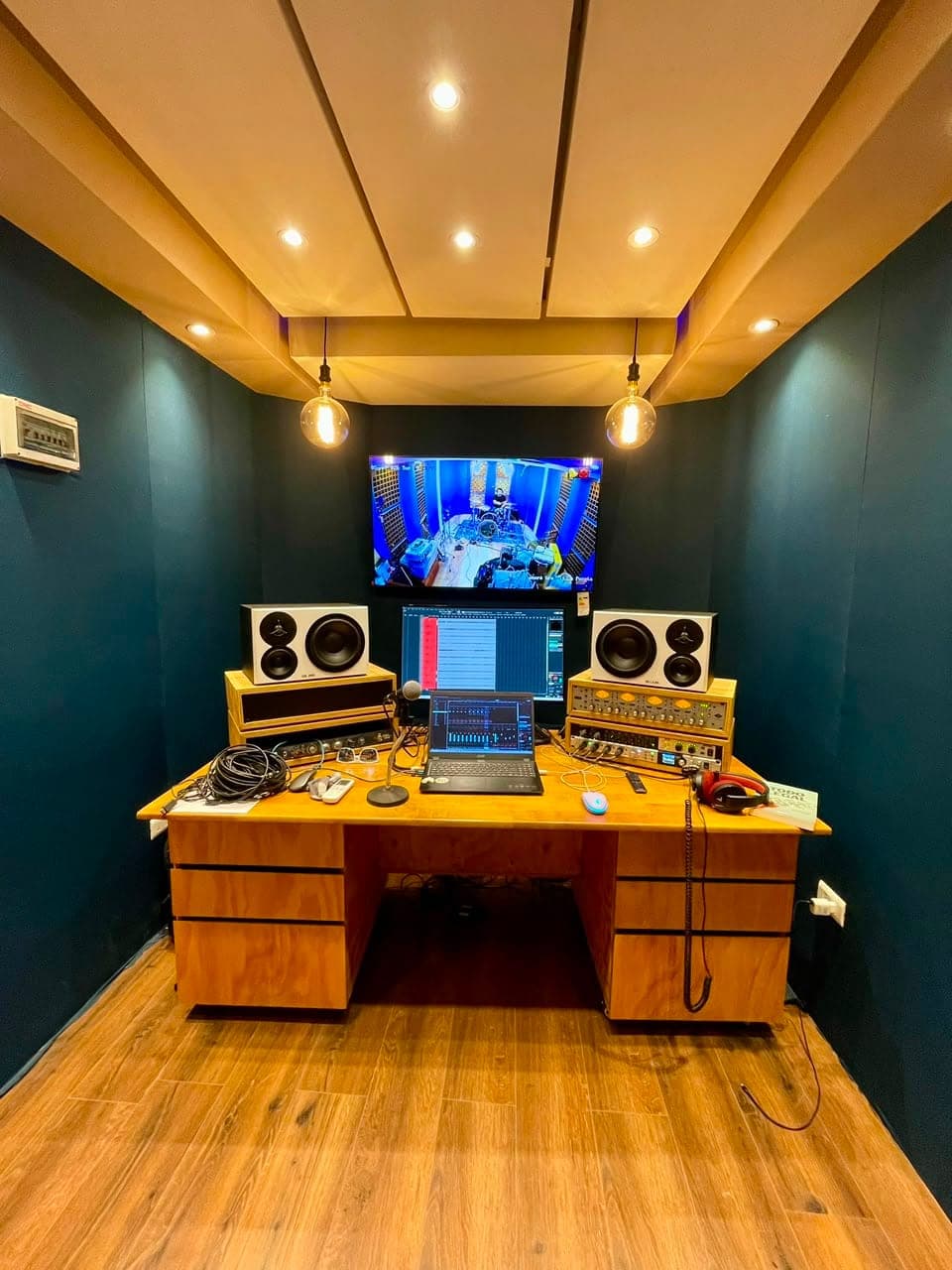 Sala de control con monitores, consola y tratamiento acústico